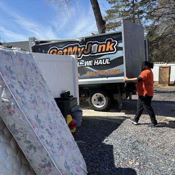 Crew carrying an old mattress out of a home for disposal in Richmond, VA