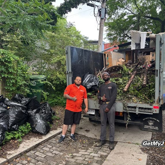 Pile of tree branches and brush being loaded for yard waste removal in Richmond, VA